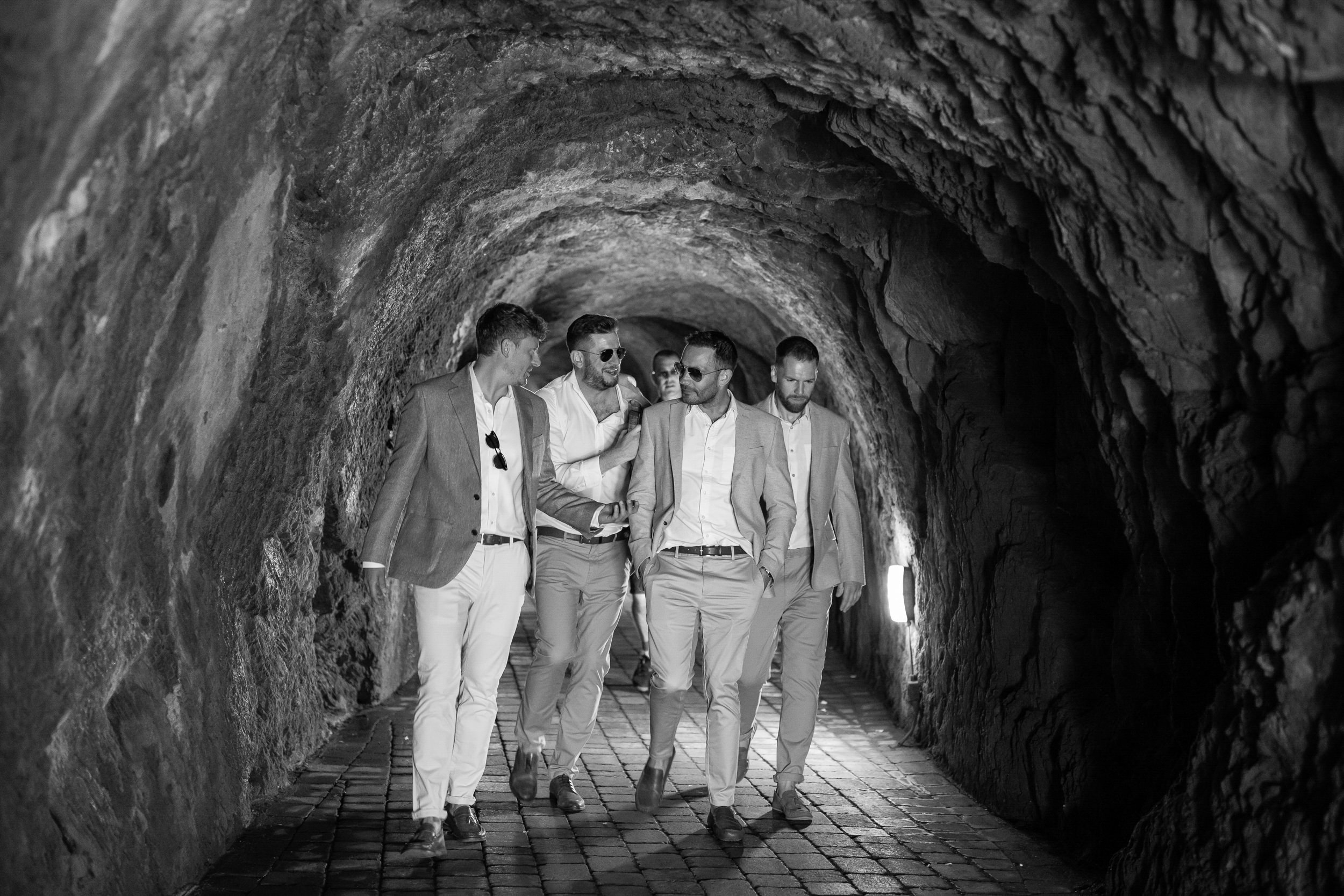 Groomsmen and Groom walking to the ceremony through the tunnels at Tunnels Beaches Devon