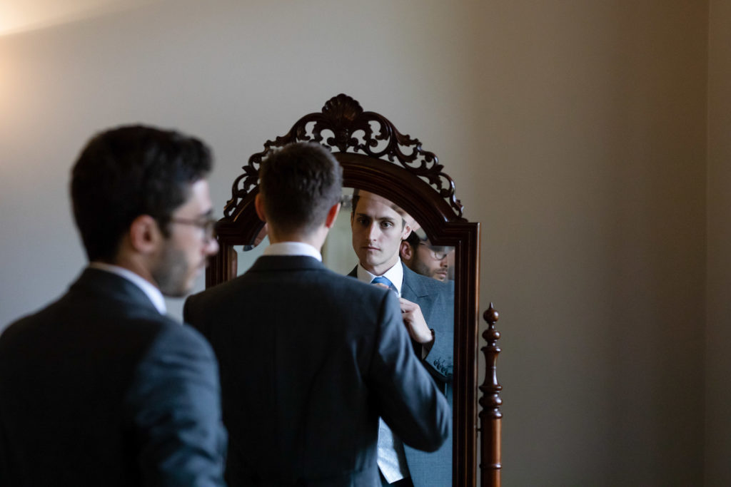 Groom in Front of Large Mirror