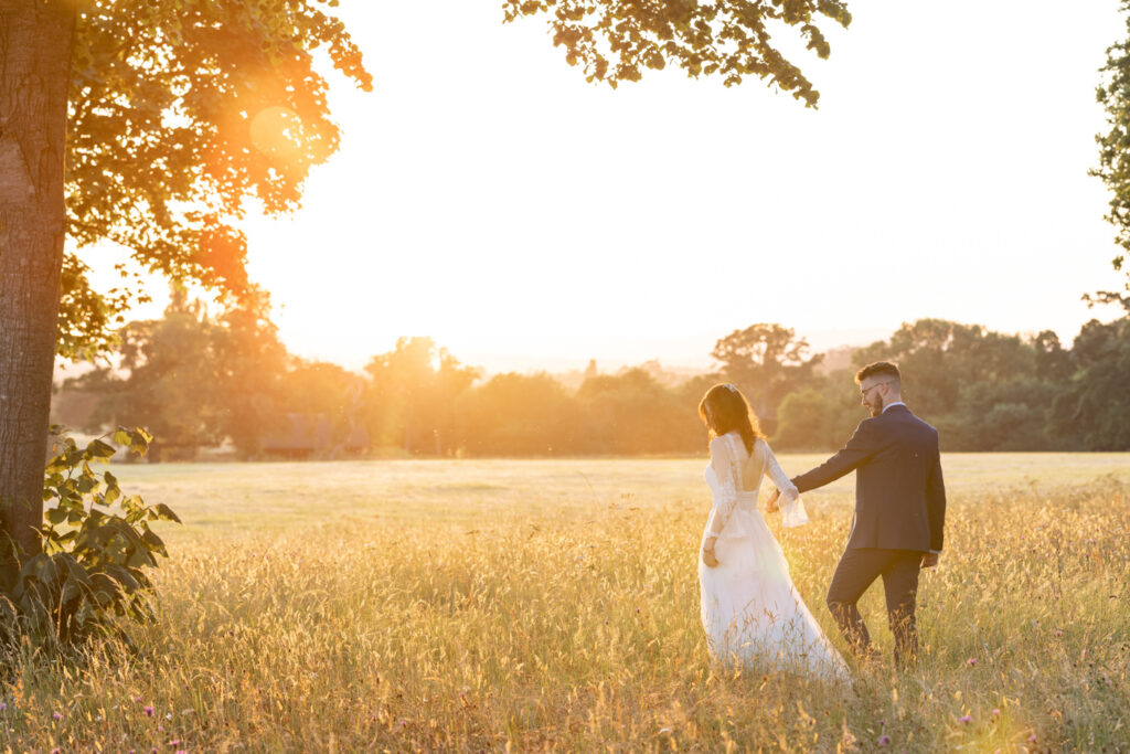 Couple walking at sunset on their wedding day at Rockbeare Manor in Devon 