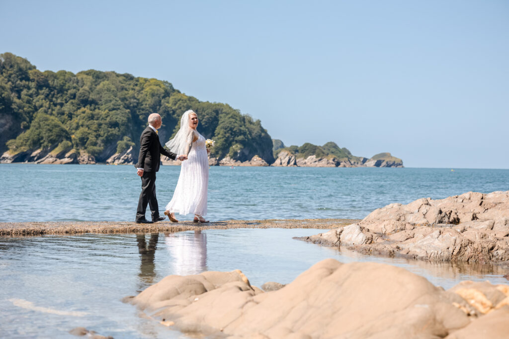 Bride and Groom Walking Next to Sea