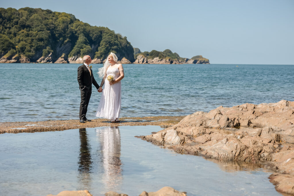 Bride and Groom Standing Next to Sea