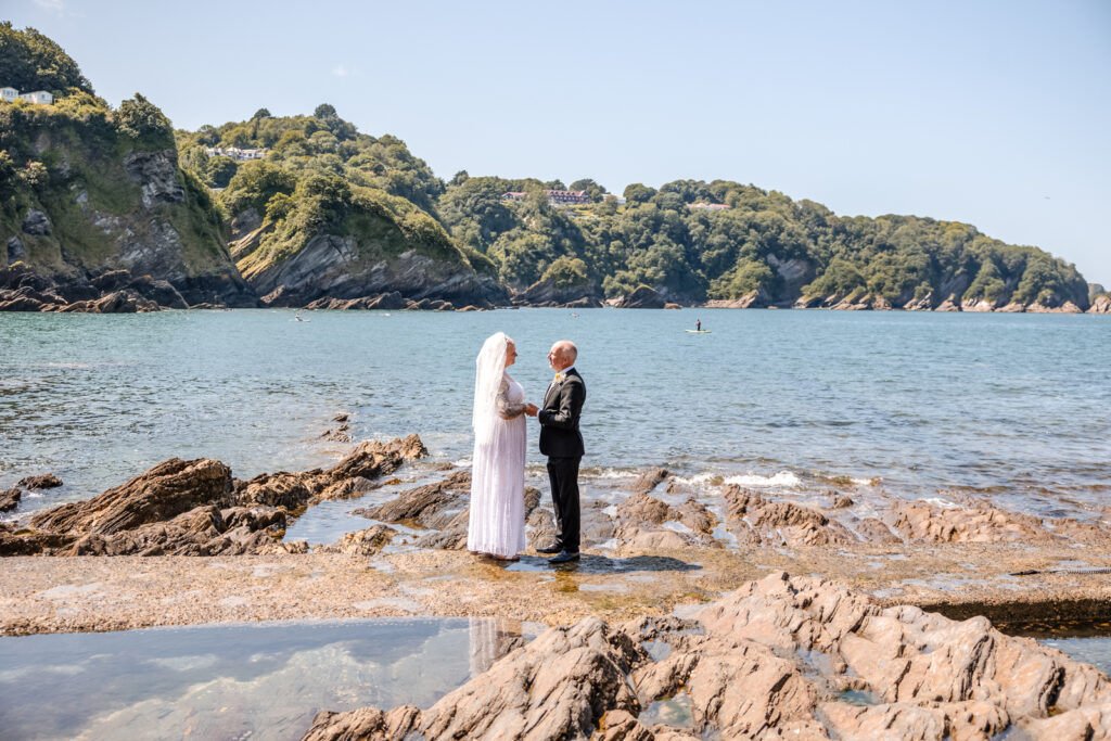 Bride and Groom Standing Next to Sea