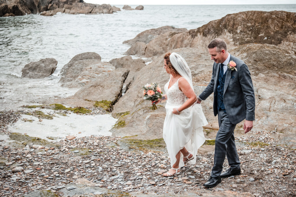 Bride and Groom Walking Across Rocks