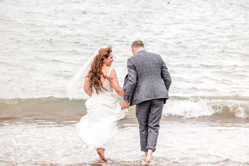 Bride and Groom Walking into the Sea